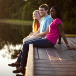 Students sitting on the dock at Lake Claire