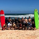 diverse group of students at the beach for a surfing trip